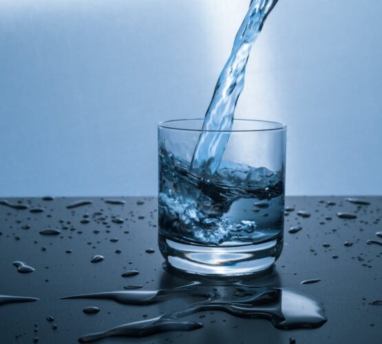 High-quality image of water being poured into a glass, illustrating hydration and purity.